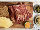 Experience the perfect St. Patrick’s Day meal or build your own corned beef kit at home with the World Spice Corned Beef Cure & Cook Kit by World Spice—just add rye bread, Swiss cheese, pickles, sauerkraut, and your favorite sauce for a classic spread arranged beautifully on a wooden cutting board or marble surface.