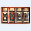 The Spice Wheel Cozy Sugar Gift Set – Vanilla, Cinnamon, Ginger & Caramel by Spice Wheel includes four glass spice jars with wooden lids, each labeled for its distinct sugar flavor: Vanilla Sugar, Cinnamon Sugar, Ginger Sugar, and Caramel Sugar. Beautifully arranged side by side in an elegant boxed set, this delightful collection is perfect for adding a sweet touch to any kitchen.