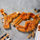 The Craftgen 3 Gun Whiskey Decanter Set by Craftgen features three borosilicate glass gun-shaped decanters filled with amber liquid, arranged on a gray stone surface—complete with shot glass, bullets, and a document for an eye-catching whiskey bar display.