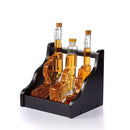 The Craftgen 3 Gun Whiskey Decanter Set by Craftgen features three lead-free borosilicate glass handgun-shaped bottles with amber liquid, displayed upright in a sleek black wooden holder—an eye-catching addition to any whiskey bar.