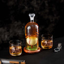 The Craftgen Baseball Decanter Set by Craftgen features a whiskey decanter with a baseball inside and two etched glasses reading "I’d Hit That"—the perfect baseball gift for any fan. A watch and cigar rest on the tabletop nearby.