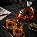 The Craftgen Football Whiskey Decanter from Craftgen, filled with rich whiskey, sits on a dark marble table with two glasses, a gold tray, a cigar, and a newspaper—unique game day barware and the perfect gift for sports fans.