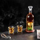 The Craftgen Golf Liquor Decanter Set by Craftgen features a golf whiskey decanter and two glasses with golf ball-shaped elements, displayed on a wooden base with green moss—an ideal gift for golf lovers.
