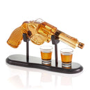The Craftgen Gun Whiskey Decanter Set by Craftgen features a gun-shaped decanter filled with amber liquid on a black stand, accompanied by two filled shot glasses—perfect for any whiskey enthusiast.