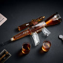 The Craftgen Rifle Whiskey Decanter Set by Craftgen features a rifle-shaped whiskey decanter with realistic details like a scope and magazine, paired with two matching shot glasses and displayed on a dark surface.