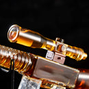 A close-up of the Craftgen Rifle Whiskey Decanter Set—a golden, glass-like collectible from Craftgen—mounted on a metallic firearm and set against a dark backdrop, ideal for collectors seeking unique barware.