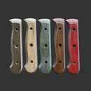 Five Messermeister Custom Driftwood Mod Kit Handles in brown, beige, green, dark brown, and red are arranged vertically on a dark gray background. Each features three holes and contoured edges for comfort.