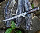 Three large catfish with metal stringers lay on wood, beside green leaves. A Texan Knives Premium Custom Handmade Damascus Steel Fillet Knife – 13” Rosewood Handle rests across them.