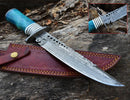 The Texan Knives Custom Handmade 13" Damascus Steel Civil War Bowie Knife features a camel bone handle with metal accents, displayed on its brown leather sheath atop rough wood; an inset highlights the blade’s intricate patterns.
