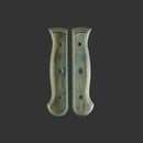 The Messermeister Custom Indigo Mod Kit Handle - Medium features two matching, curved wooden scales with holes, designed as knife handles, displayed symmetrically on a dark background.