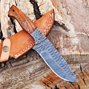 The Texan Knives Custom Handmade 5-Inch Damascus Skinning Knife with a patterned blade and rosewood handle from Texan Knives rests on its brown leather sheath atop rough tree bark.