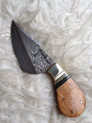 The Texan Knives Custom Handmade Damascus Skinning Knife features a 3" patterned steel blade and a rosewood handle with brass accents, shown on a light, textured surface.