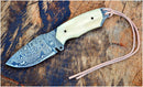The Texan Knives Custom Handmade Damascus Steel Skinning Knife, featuring a 4" patterned blade and camel bone handle, rests on a textured wooden surface—an ideal outdoor gift for hunters by Texan Knives.