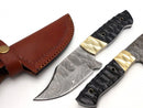 The Texan Knives Custom Handmade Damascus Skinning Knife by Texan Knives features a patterned blade and a resin & brass handle, displayed next to a brown stitched leather sheath with buttoned strap—ideal for hunting or skinning.