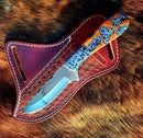 The Texan Knives Custom Handmade Knife with a 3.5" rasp tool blade and resin handle rests in its belt sheath atop a brown, textured fur surface.