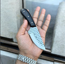 A hand holds the Texan Knives Custom Handmade Cowboy Knife, featuring a rasp steel blade and a resin handle; the person is wearing a silver watch.