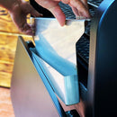 A person’s hand installing a Pimp My Grill® Bodyguard Stainless Steel Grease & Paint Protector inside a Green Mountain Grills Ledge 1.0 pellet grill.