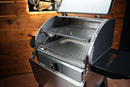 A stainless steel Camp Chef Woodwind 24 pellet grill with its lid open, revealing the Pimp My Grill® Gen2 Slide-Out Rack System - 2 Racks with two stacked slide-out metal wire racks.