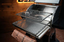 Two Pimp My Grill® Gen2 Slide-Out Rack System - 2 Racks stainless steel slide-out grill racks installed inside a Camp Chef Woodwind 24 for a two-level cooking setup, with a sheet of printed butcher paper draped over the front.