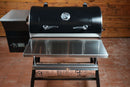 Black Recteq Patio Legend 410 pellet grill with a Pimp My Grill® Tactical Stainless Folding Front Shelf and a side digital control panel.