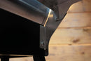 Close-up of a Pimp My Grill® Tactical Stainless Folding Front Shelf attached to the front of a black Recteq Patio Legend 410 grill.