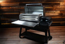 Traeger Ironwood XL with an open lid and a Pimp My Grill® Tactical Stainless Folding Front Shelf for added prep space.