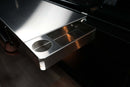 Traeger Ironwood XL | Pimp My Grill® Tactical Stainless Folding Front Shelf attached to a grill, featuring a recessed rectangular tray and a circular drink holder for extra prep space.