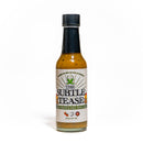 A bottle of California Hot Sauce Solutions CHSS The Subtle Tease Hot Sauce, featuring a black cap and a decorative label with chili pepper graphics, crafted as a unique fermented green hot sauce.