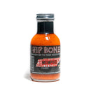 A bottle of California Hot Sauce Solutions Hip Bone Memphis BBQ Sauce with an orange-red, tomato-based BBQ sauce inside, a black cap, and a black label featuring bold text and a Memphis graphic. The bottle is standing on a white background.