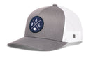 The Haka Hat Dallas Trucker Hat features a gray and white mesh design with a round blue DAL X football patch on the front. This snapback offers classic style for fans.