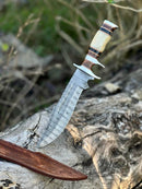 The Texan Knives Damascus Steel Sub-Hilt Fighter Bowie Knife 14” features an ornate patterned blade, a bone and wood handle, and comes with a brown leather sheath—an ideal premium Christmas gift for collectors.