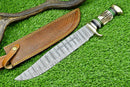 The Texan Knives Custom Handmade Damascus Steel Bowie Knife features a 16" patterned blade, stag horn handle, and comes with a brown leather sheath, displayed on green grass next to a deer antler.