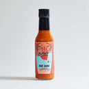 A bottle of Culture Hot Sauce The Don by Culture Hot Sauce, featuring a beach and palm tree illustration on the label, contains their original recipe Pineapple Habanero hot sauce and is displayed against a plain white background.