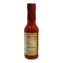 A glass bottle of Powerful Pepper Company’s Dr. Gleaton’s Chili Elixir Barrel Aged Hot Sauce stands upright on a white background. The Louisiana-style hot sauce features a red cap and label, which displays nutrition facts and ingredients such as water, jalapeno, habanero, garlic, and salt. This is a fermented pepper sauce.