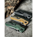 Three Spaceman Knives N1 EDC folding knives with tough black, yellow, and green Micarta handles are arranged on a grey surface by a chunk of wood—an ideal daily carry set from Spaceman Knives.