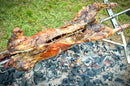 A piece of SpitJack 7" Stainless Steel Meat Trussing Needle and Butcher's Cooking Twine Bundle is being cooked on a grill.