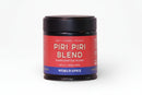 A 1.83 oz (52g) jar of World Spice Piri Piri Blend seasoning from World Spice, featuring a red label and black lid, displays descriptors Heat • Citrusy • Picante. This handcrafted blend highlights the vibrant kick of African chiles for an authentic flavor experience.