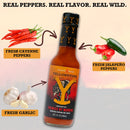 Bottle of Elijah's Xtreme Enemies by Morning (Roasted Jalapeño) hot sauce with arrows pointing to fresh cayenne peppers, jalapeño peppers, and garlic, set against a rustic background. Text reads: “Real Peppers. Real Flavor. Real Wild.” This roasted pepper hot sauce from Elijah’s Xtreme brings bold flavor straight from the wild to your table.