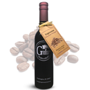 A bottle of Georgetown Olive Oil Co. Espresso Balsamic Vinegar, crafted in Modena, Italy, with a brown tag from Georgetown Olive Oil Co., stands in front of scattered coffee beans on a white background.