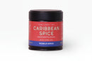 A jar of World Spice Caribbean Spice handcrafted blend from World Spice, featuring a red label with white text and a black lid. Infused with bold Caribbean seasoning notes such as habanero and allspice, the jar displays the descriptions “Warm, Citrusy, Heat,” and “NET WT. 2.19 OZ (62g)” against a plain white background.