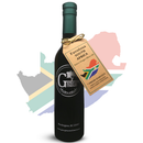 A dark bottle of Georgetown Olive Oil Co. Favolosa (SOUTH AFRICA) Extra Virgin Olive Oil, adorned with a brown tag and featuring the South African flag, stands before a faded map and flag of South Africa. Proudly crafted in South Africa, this high polyphenol extra virgin olive oil from Georgetown Olive Oil Co. offers outstanding quality and flavor.