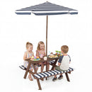 Three kids enjoy snacks at the Fir Wood Kids Picnic Table with 2 Built-in Benches and Umbrella by DirectDeals. Two girls share one side, a boy sits opposite. Bright and cheerful atmosphere.
