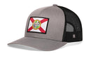 The Haka Hat Florida Flag Trucker Hat features a gray and white design with a mesh back, comfort-fit snapback, and a Florida state flag patch on the front.