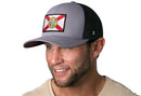 A man wearing a Haka Hat Florida Flag Trucker Hat, Gray-White FL Snapback, smiles while looking slightly left.