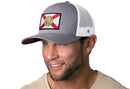 A smiling man wears a beige shirt and a Haka Hat Florida Flag Trucker Hat—Black FL Snapback by Haka Hat, featuring a Florida state flag patch on the front.