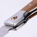 Close-up of the Messermeister Folding Steak Knife - 4" highlights its metal blade, wooden handle, locking mechanism, and a visible screw—offering a travel-friendly solution from Messermeister for on-the-go dining needs.