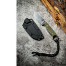 The Spaceman Knives Halimede Fixed Blade Knife, featuring a green Micarta handle and black lanyard, rests beside its black sheath on a textured gray surface; made with durable D2 steel by Spaceman Knives.