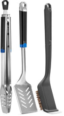 The Napoleon Grills 3-Piece Starter Tool Set Essential Series (GATL002) includes stainless steel tongs, a slotted spatula, and a Palmyra bristle grill brush with black handles and hanging loops. Ideal as a beginner's grilling tool set.
