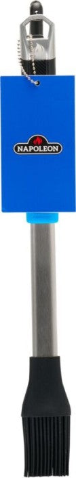 The Napoleon Grills Silicone Basting Brush Essential Series (GATL005) features heat-resistant bristles and a stainless steel handle, shown vertically with a blue label—an essential grilling accessory.