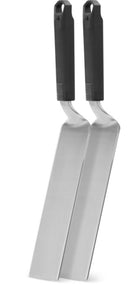 The Napoleon Griddle Spatula 2-Piece Set by Napoleon Grills (GATL011), featuring long, flat stainless steel blades and black textured handles, stands upright side by side against a white background.